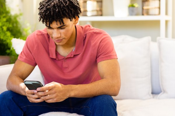 smiling-biracial-man-using-smartphone-sitting-on-s-2026-01-09-08-41-45-utc